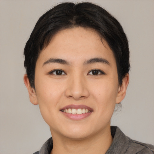 Joyful asian young-adult female with short  brown hair and brown eyes