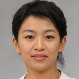 Joyful asian young-adult female with short  brown hair and brown eyes