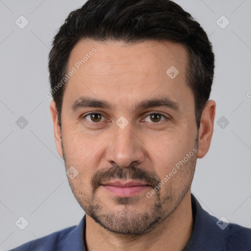 Joyful white adult male with short  black hair and brown eyes