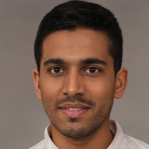 Joyful latino young-adult male with short  black hair and brown eyes