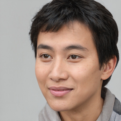 Joyful asian young-adult male with short  brown hair and brown eyes