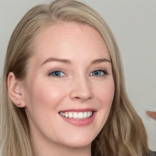 Joyful white young-adult female with long  brown hair and blue eyes