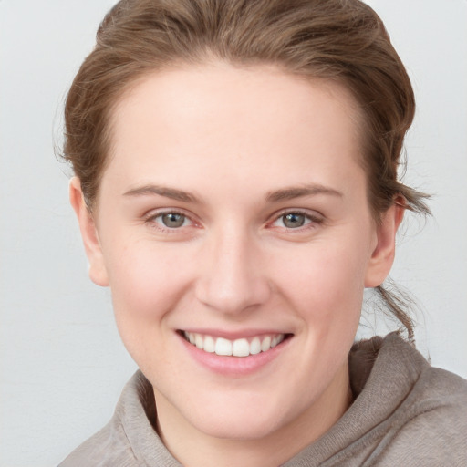 Joyful white young-adult female with short  brown hair and blue eyes