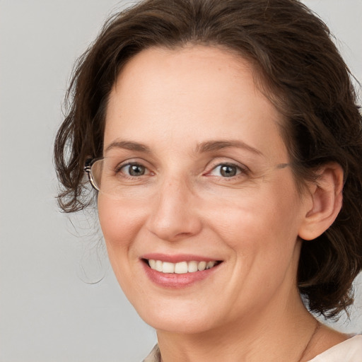 Joyful white adult female with medium  brown hair and grey eyes