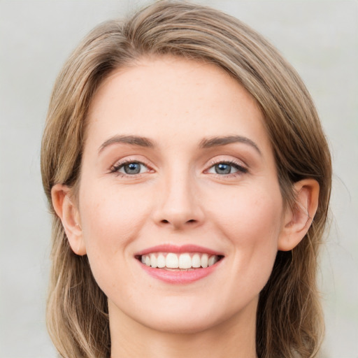 Joyful white young-adult female with medium  brown hair and green eyes