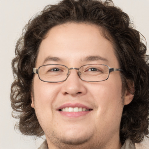 Joyful white adult male with medium  brown hair and green eyes