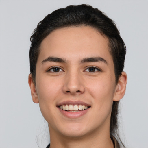 Joyful white young-adult male with long  brown hair and brown eyes