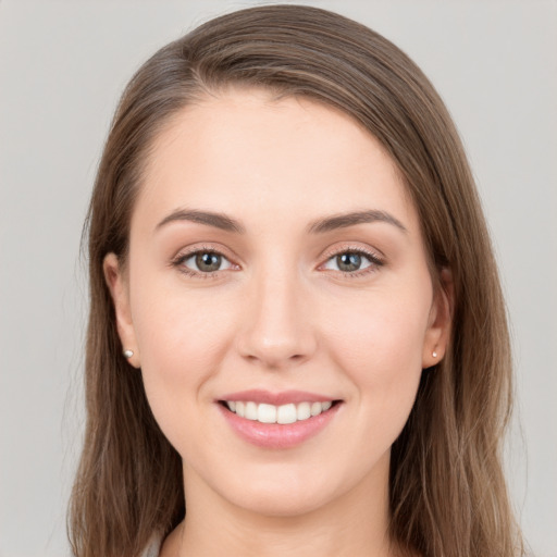 Joyful white young-adult female with long  brown hair and grey eyes