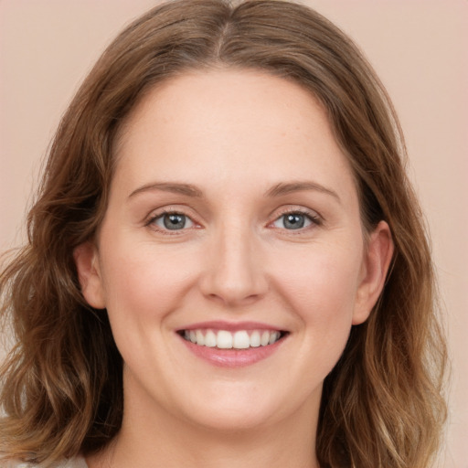 Joyful white young-adult female with long  brown hair and blue eyes