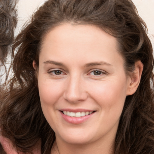 Joyful white young-adult female with long  brown hair and brown eyes