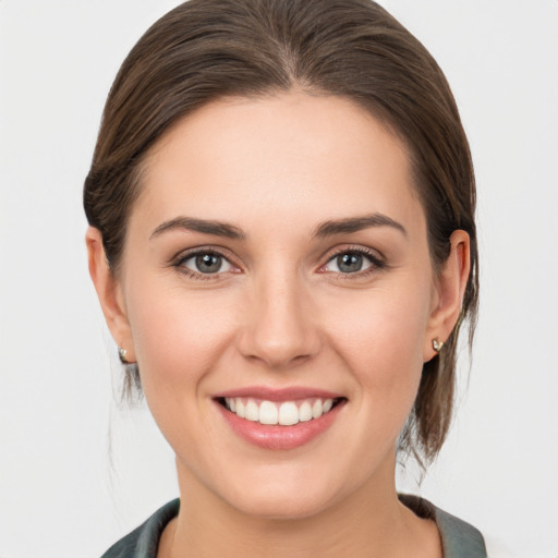 Joyful white young-adult female with medium  brown hair and grey eyes