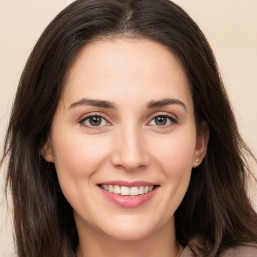 Joyful white young-adult female with long  brown hair and brown eyes