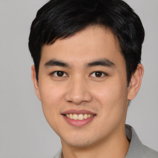 Joyful asian young-adult male with short  black hair and brown eyes