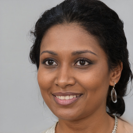 Joyful black young-adult female with medium  brown hair and brown eyes