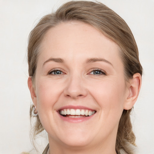 Joyful white adult female with medium  brown hair and blue eyes