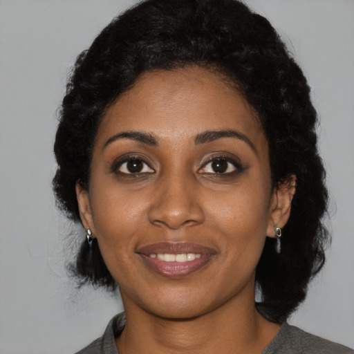 Joyful black young-adult female with short  black hair and brown eyes