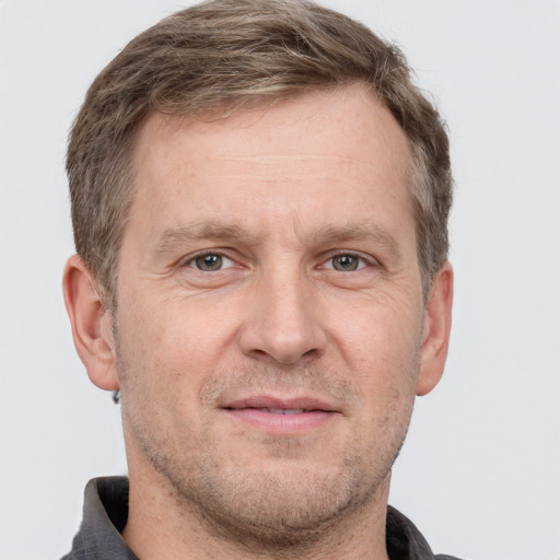 Joyful white adult male with short  brown hair and grey eyes