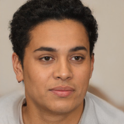 Joyful latino young-adult male with short  brown hair and brown eyes