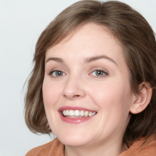 Joyful white young-adult female with medium  brown hair and blue eyes