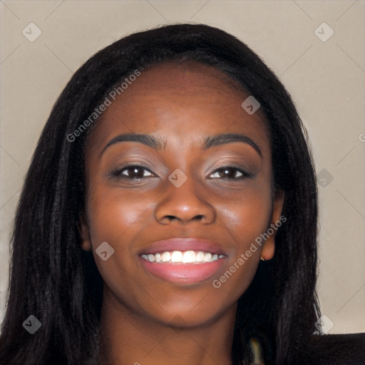 Joyful black young-adult female with long  black hair and brown eyes