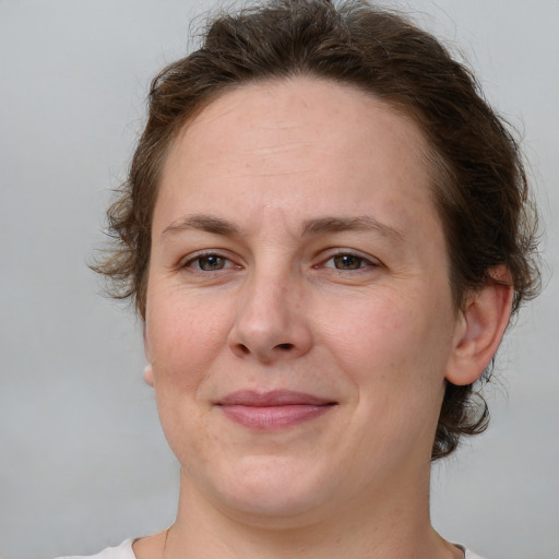 Joyful white adult female with medium  brown hair and grey eyes