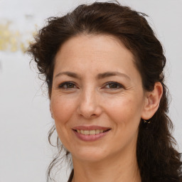 Joyful white adult female with long  brown hair and brown eyes