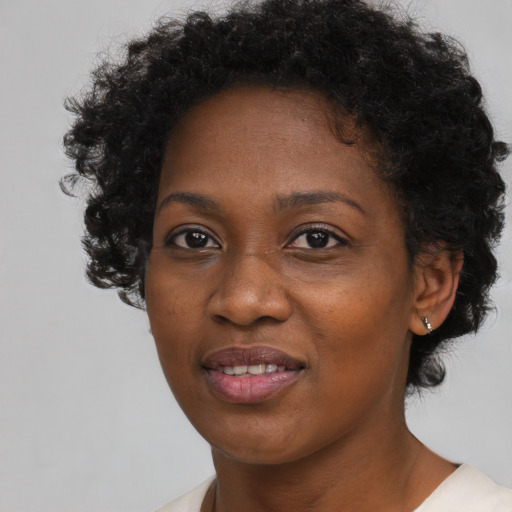 Joyful black young-adult female with short  brown hair and brown eyes