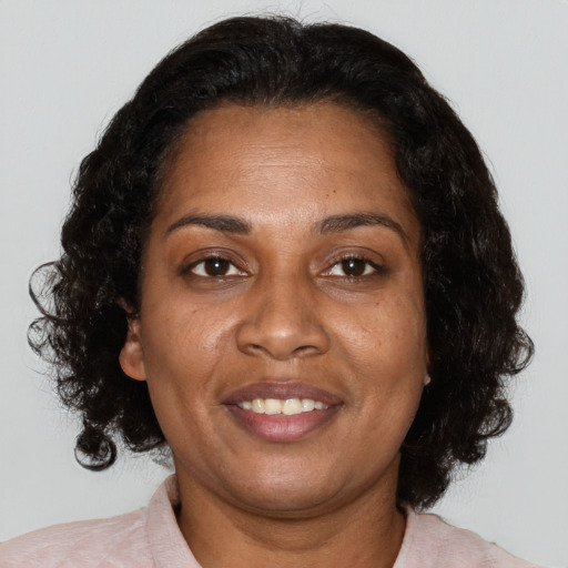 Joyful black adult female with medium  brown hair and brown eyes