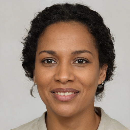 Joyful black young-adult female with medium  brown hair and brown eyes