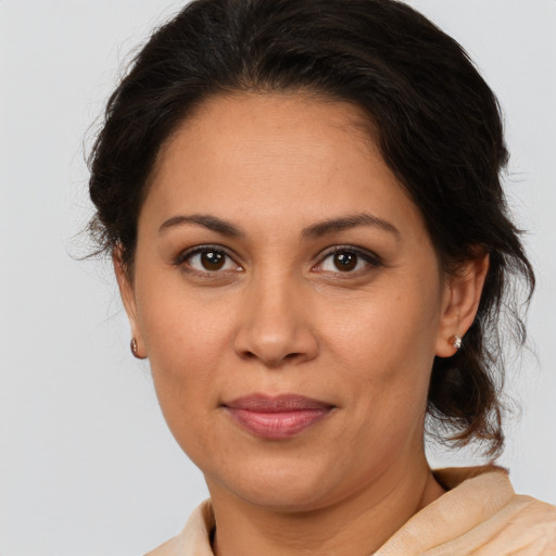 Joyful latino adult female with medium  brown hair and brown eyes