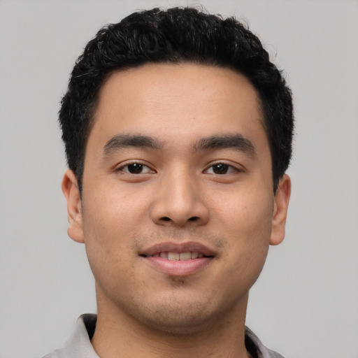 Joyful latino young-adult male with short  black hair and brown eyes