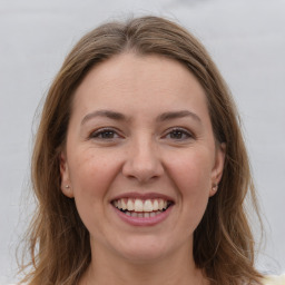 Joyful white young-adult female with long  brown hair and grey eyes