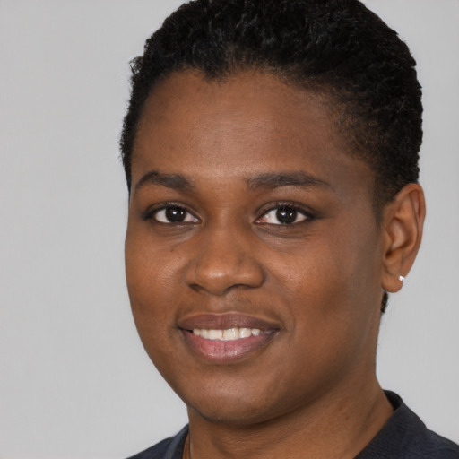 Joyful black young-adult female with short  black hair and brown eyes