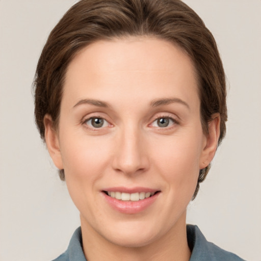 Joyful white young-adult female with medium  brown hair and grey eyes