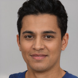 Joyful white young-adult male with short  black hair and brown eyes