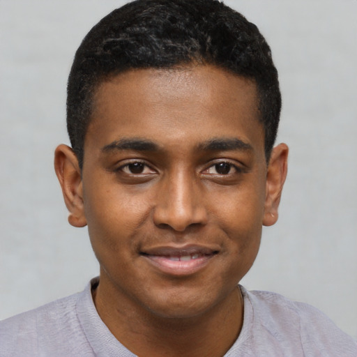 Joyful black young-adult male with short  brown hair and brown eyes