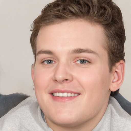 Joyful white young-adult male with short  brown hair and blue eyes