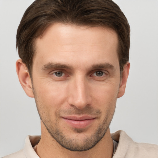 Joyful white young-adult male with short  brown hair and grey eyes