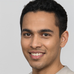 Joyful latino young-adult male with short  black hair and brown eyes