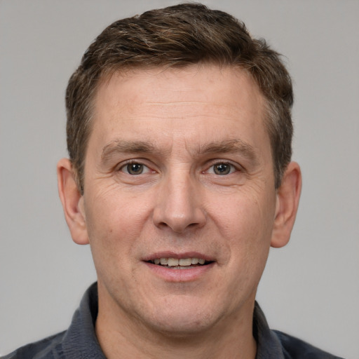 Joyful white adult male with short  brown hair and grey eyes