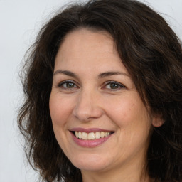 Joyful white adult female with long  brown hair and brown eyes