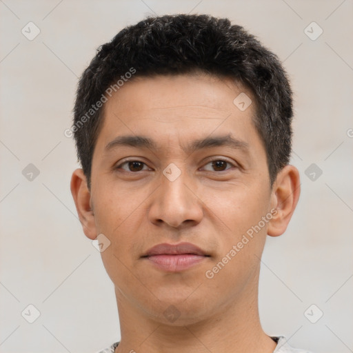 Joyful latino young-adult male with short  black hair and brown eyes