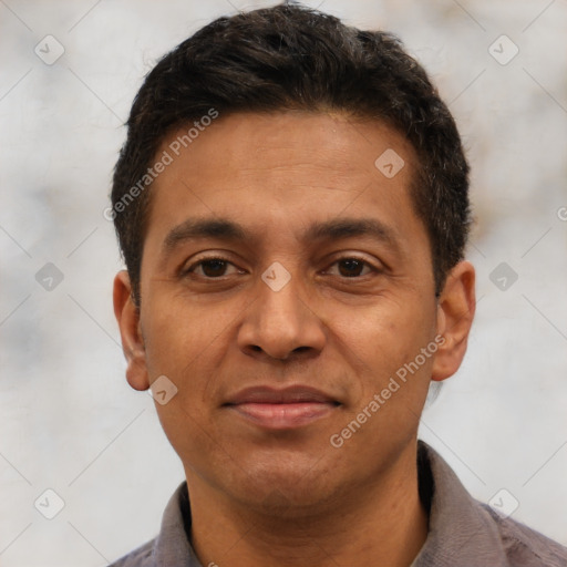 Joyful latino adult male with short  brown hair and brown eyes