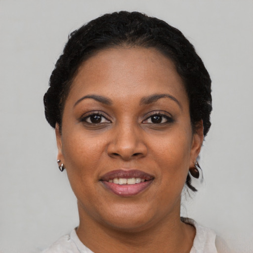 Joyful black young-adult female with short  black hair and brown eyes