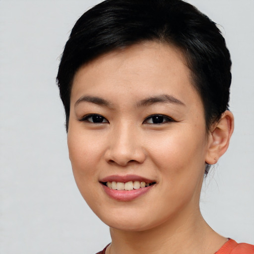 Joyful asian young-adult female with short  black hair and brown eyes