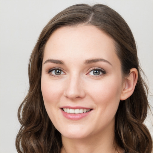 Joyful white young-adult female with long  brown hair and green eyes