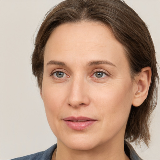 Joyful white adult female with medium  brown hair and grey eyes