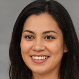 Joyful latino young-adult female with long  brown hair and brown eyes