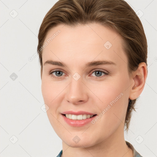 Joyful white young-adult female with medium  brown hair and grey eyes