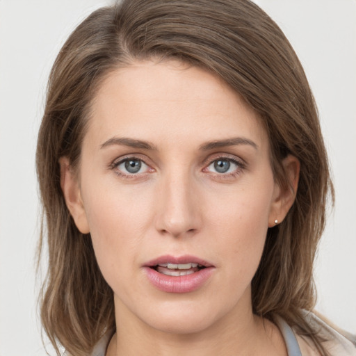 Joyful white young-adult female with medium  brown hair and grey eyes